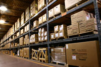 A row of pallet racks in a warehouse holding boxes of various sizes.